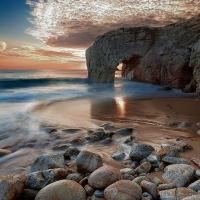 Am image of the sea and seas shore with rocks and a coast rocky mountain 