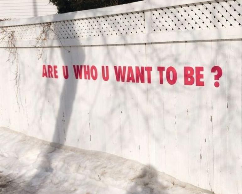 a wall that has the words "are you who you want to be"