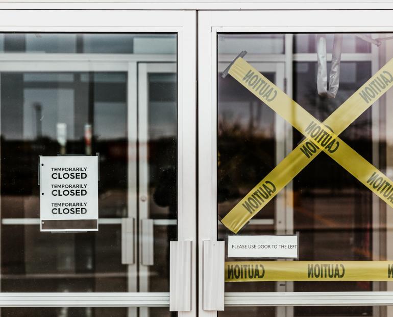 The outside of a business with a temporarily closed sign.