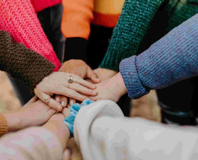 Friends hands piled together.