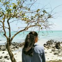 A girl with a beach in the background 