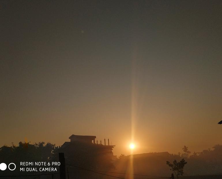 The winter morning sun amidst the dense fog rising from beside a RCC House