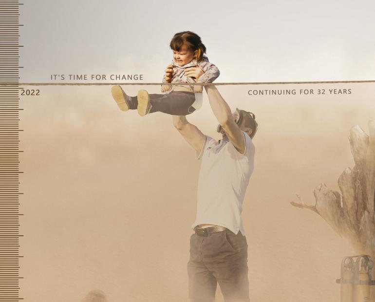 Illustration by Murtada Yeshar Abdulwahid. A man in a polluted environment wearing a gas mask upholds a child. The child is above a line marked by year 2022, in a much cleaner environment. The illustration reads "It's time for change."
