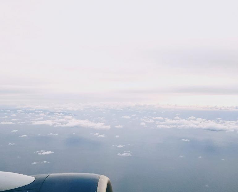 Plane engine over water and clouds