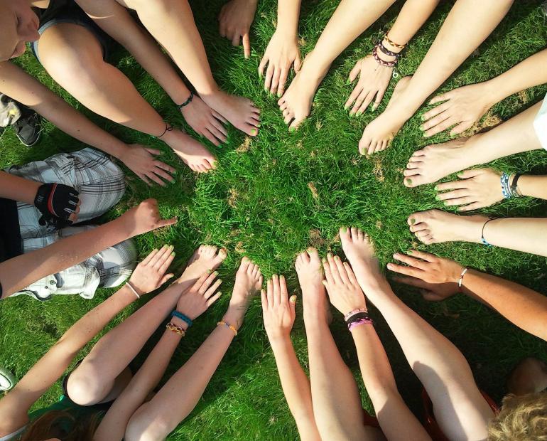 Manos reunidas al centro en forma de unidad.