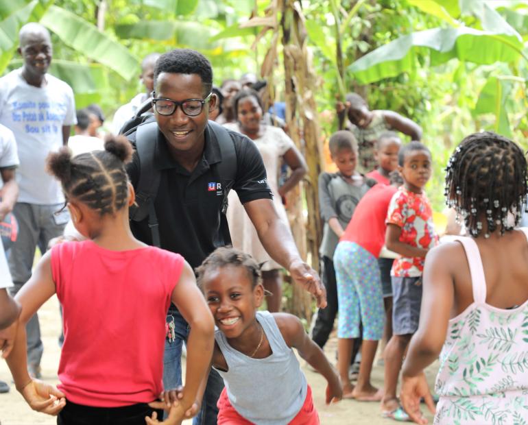 Joseph, a U-Reporter, plays with children in the IDP camps of Haiti as part of psychosocial support in UNICEF's humanitarian response.