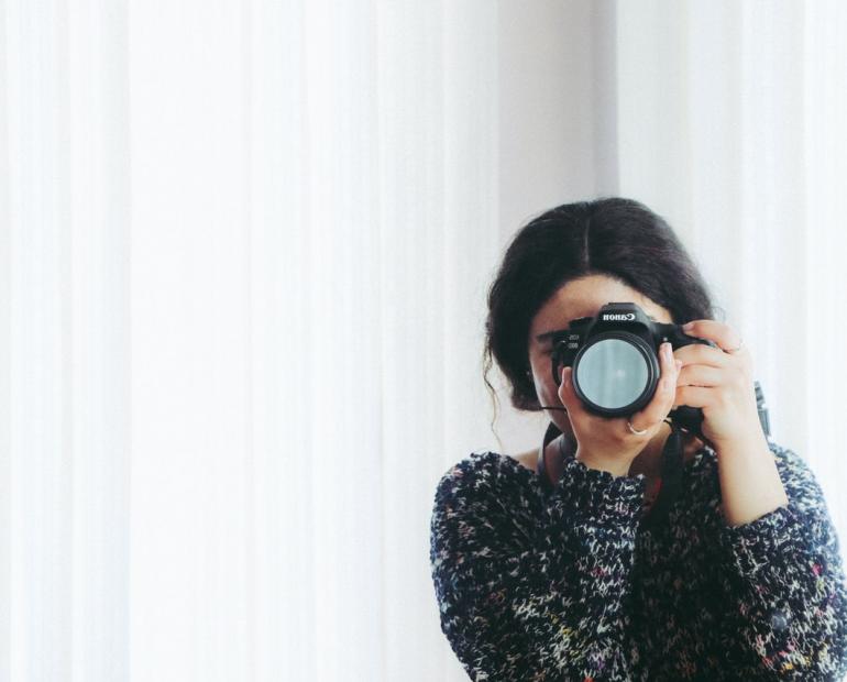 A woman holds up a camera